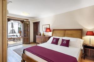 a bedroom with a large bed with purple pillows at Relais 147 - Luxury b&b in Taormina