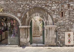 an entrance to a stone building with an arch at Relais 147 - Luxury b&b in Taormina
