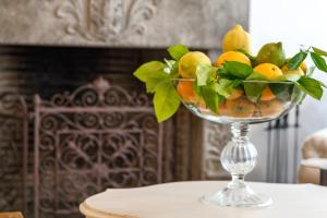 a glass bowl filled with lemons on a table at Relais 147 - Luxury b&b in Taormina