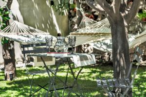 a table and chairs with a vase on it at Relais 147 - Luxury b&b in Taormina