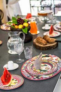 a table with plates of food and fruit on it at Relais 147 - Luxury b&b in Taormina