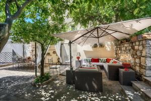 a patio with a couch and an umbrella at Relais 147 - Luxury b&b in Taormina
