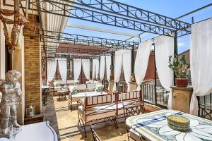 a patio with tables and chairs on a balcony at Relais 147 - Luxury b&b in Taormina