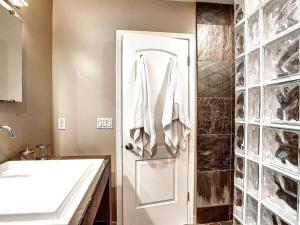 a bathroom with a sink and a white door at Kierland Villa · North Scottsdale Home w/Pool~Walk to Kierland Area in Scottsdale +8 photos