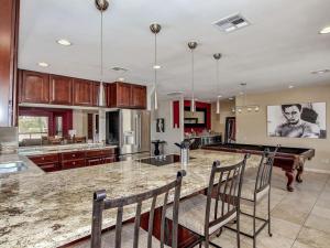 Kierland Villa · North Scottsdale Home w/Pool~Walk to Kierland Area في سكوتسديل: مطبخ مع جزيرة كبيرة مع كراسي وبيانو