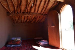 Cette chambre est dotée d'un plafond en bois et d'une porte ouverte. dans l'établissement Nomadic Life Camp, à M'Hamid El Ghizlane