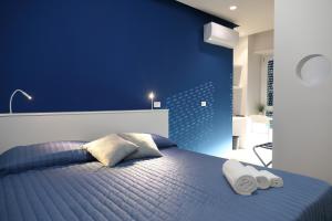 ein blaues Schlafzimmer mit einem Bett mit Handtüchern darauf in der Unterkunft B&B Oblò in Catania