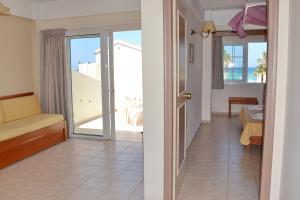 Habitación con una puerta que conduce a una habitación con balcón. en Galeana Mare Hotel Apartments by Gasparakis, en Adelianos Kampos