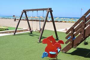 a swing set at a playground at the beach at Galeana Mare Hotel Apartments by Gasparakis in Adelianos Kampos