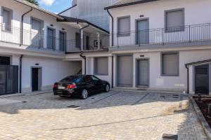 un coche negro estacionado frente a un edificio en Home Hotel, en Senago