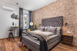 a bedroom with a brick wall and a bed at Porto Marina apartments in Rijeka