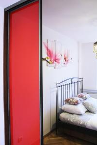 a red sliding door in a bedroom with a bed at Cozy and great location by Cooee Apartments in Warsaw