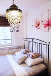 een slaapkamer met een bed met een kroonluchter bij Cozy and great location by Cooee Apartments in Warschau