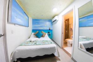 a small bedroom with a bed and a mirror at Casa Noir Cartagena in Cartagena de Indias