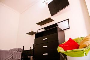 1 dormitorio con vestidor negro y TV en la pared en Casa Fanny, en Cartagena de Indias