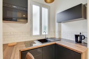 a kitchen with a sink and a microwave at Cosy Studio en plein centre ville de Fontainebleau in Fontainebleau