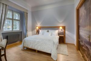 a bedroom with a white bed and a window at Chateau Herálec Boutique Hotel & Spa by L'Occitane in Herálec