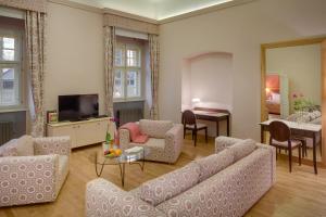 a living room with a couch and a dining room at Chateau Herálec Boutique Hotel & Spa by L'Occitane in Herálec