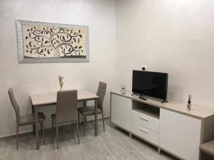 a dining room with a table and a tv at La Maison Doppia in Stornara