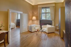 a living room with two white chairs and a window at Chateau Herálec Boutique Hotel & Spa by L'Occitane in Herálec