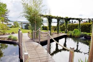 a wooden bridge over a pond in a garden at Ferienwohnung Altefaehr mit Seebli in Altefähr