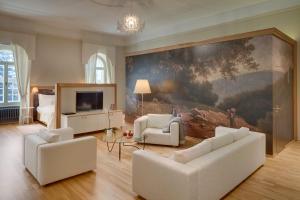 a living room with white furniture and a large painting at Chateau Herálec Boutique Hotel & Spa by L'Occitane in Herálec