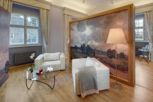 a living room with a large painting on the wall at Chateau Herálec Boutique Hotel & Spa by L'Occitane in Herálec
