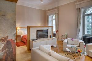 a living room with a couch and a tv at Chateau Herálec Boutique Hotel & Spa by L'Occitane in Herálec