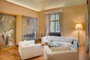 a living room with white furniture and a painting at Chateau Herálec Boutique Hotel & Spa by L'Occitane in Herálec