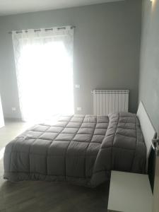 een slaapkamer met een groot bed en een groot raam bij Affittacamere New Lifestyle in Alberoro
