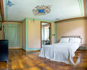 a bedroom with a bed and a ceiling with a painting at Ca’d’ambra in Groscavallo