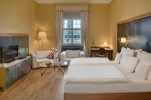 a hotel room with a large bed and a television at Chateau Herálec Boutique Hotel & Spa by L'Occitane in Herálec