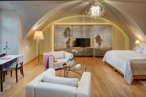 a bedroom with a bed and a living room at Chateau Herálec Boutique Hotel & Spa by L'Occitane in Herálec