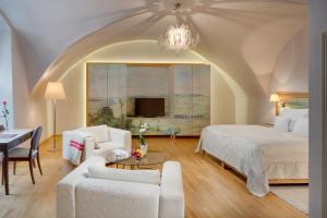 a bedroom with a bed and a couch and a table at Chateau Herálec Boutique Hotel & Spa by L'Occitane in Herálec