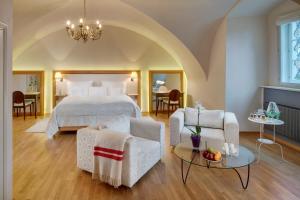 a bedroom with a bed and chairs and a table at Chateau Herálec Boutique Hotel & Spa by L'Occitane in Herálec