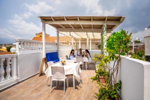 a balcony with people sitting at a table on a roof at Casa Noir Cartagena in Cartagena de Indias
