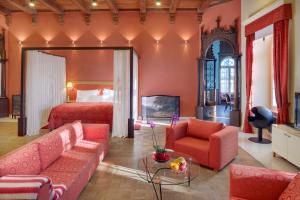 a bedroom with a bed and a living room with a couch at Chateau Herálec Boutique Hotel & Spa by L'Occitane in Herálec