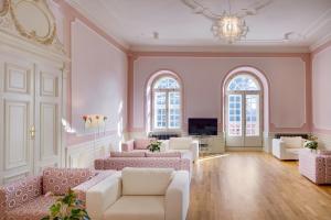 a large living room with pink walls and white furniture at Chateau Herálec Boutique Hotel & Spa by L'Occitane in Herálec