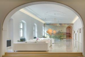 an archway in a living room with a white couch at Chateau Herálec Boutique Hotel & Spa by L'Occitane in Herálec