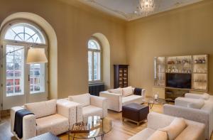 a living room with white furniture and a tv at Chateau Herálec Boutique Hotel & Spa by L'Occitane in Herálec