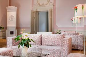a living room with a couch and a vase of flowers at Chateau Herálec Boutique Hotel & Spa by L'Occitane in Herálec