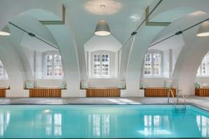 a swimming pool in a room with windows at Chateau Herálec Boutique Hotel & Spa by L'Occitane in Herálec