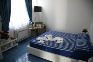 ein Schlafzimmer mit einem blauen und weißen Bett mit weißen Handtüchern in der Unterkunft Il Sestante B&B in Condofuri