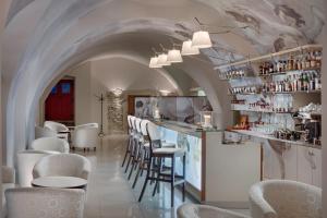 a restaurant with a bar with white chairs and tables at Chateau Herálec Boutique Hotel & Spa by L'Occitane in Herálec