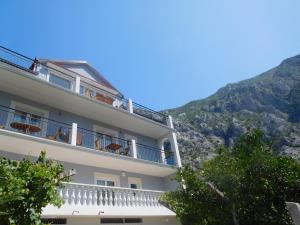 un edificio con balconi con montagne sullo sfondo di Villa Aronija a Kotor (Cattaro)