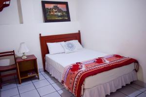 1 dormitorio con 1 cama y 1 mesa con lámpara en Hotel San Jose de la Montaña en San Salvador