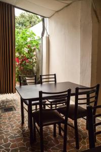 mesa y sillas en una habitación con ventana en Hotel San Jose de la Montaña en San Salvador