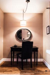 a mirror on a wall above a desk with a chair at Hotel Normandie - Los Angeles in Los Angeles