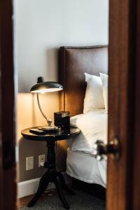 a bedroom with a bed and a table with a lamp at Hotel Normandie - Los Angeles in Los Angeles