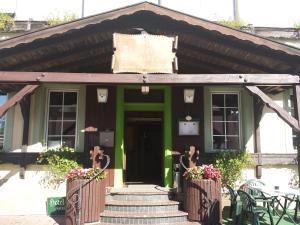 un bâtiment vert avec un panneau à l'avant dans l'établissement Hotel Dorfschenke, à Pirmasens